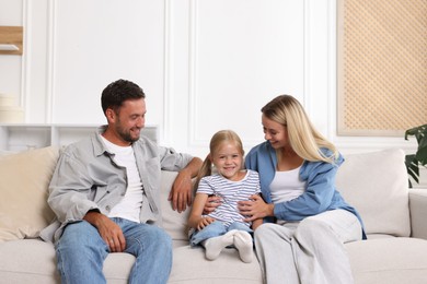 Photo of Happy family spending time together on sofa at home