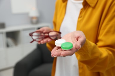 Photo of Woman choosing between glasses and contact lenses indoors, closeup. Space for text