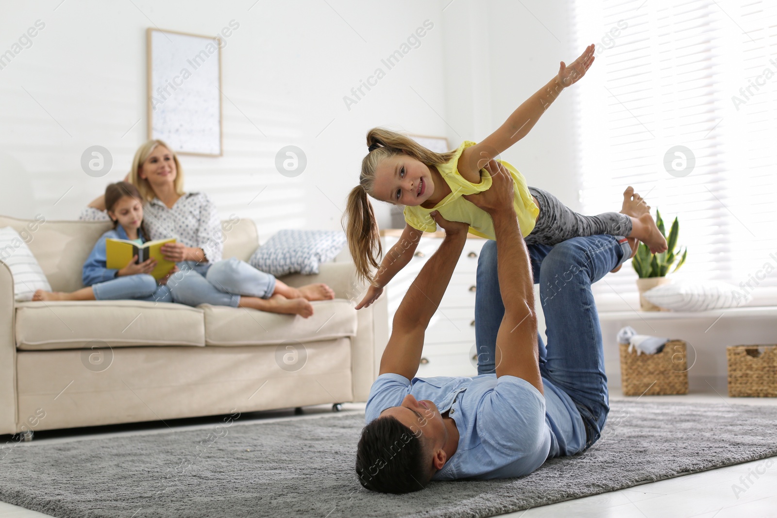 Happy father playing with his daughter on floor at home Photo of Happy father playing with his daughter on floor at home