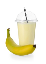 Photo of Tasty banana milkshake in plastic cup and fresh fruit isolated on white