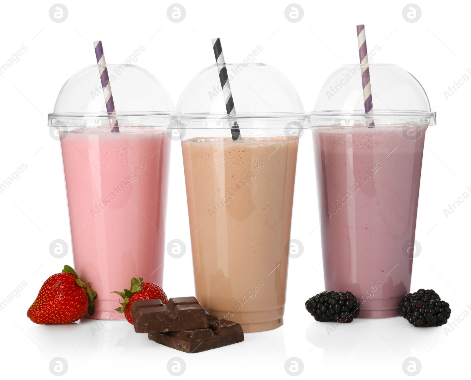 Photo of Milkshakes of different flavors in plastic cups and ingredients isolated on white