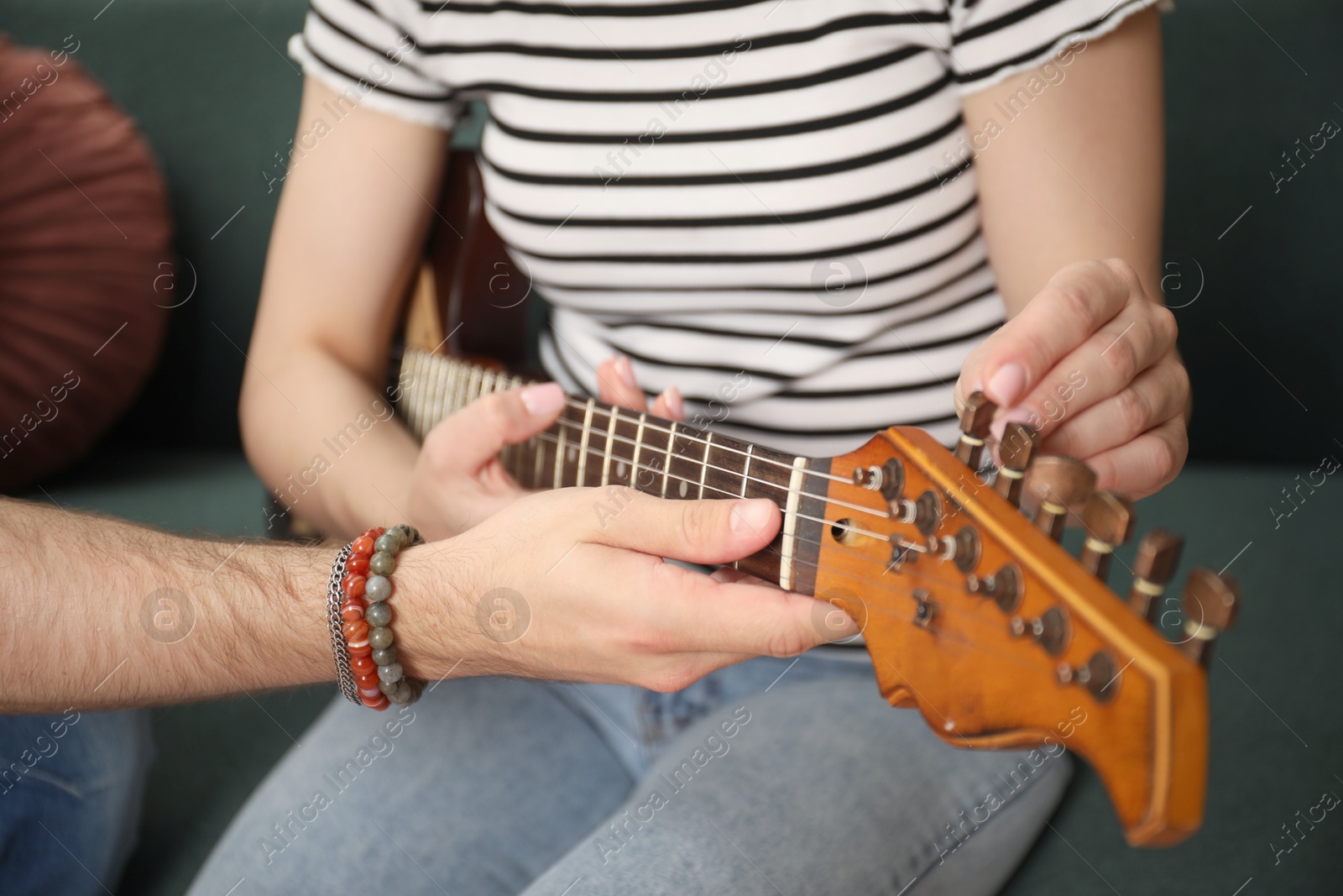 Tutor teaching woman to play guitar at home, closeup Photo of Tutor teaching woman to play guitar at home, closeup