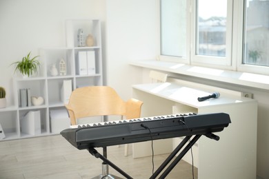 Photo of Modern electric piano and chair at home
