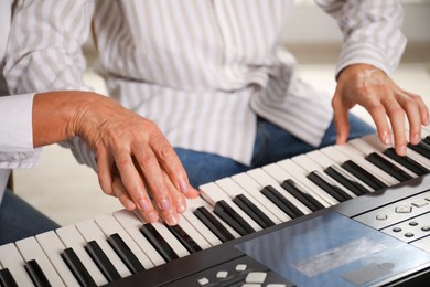 Photo of Tutor teaching man to play piano indoors, closeup