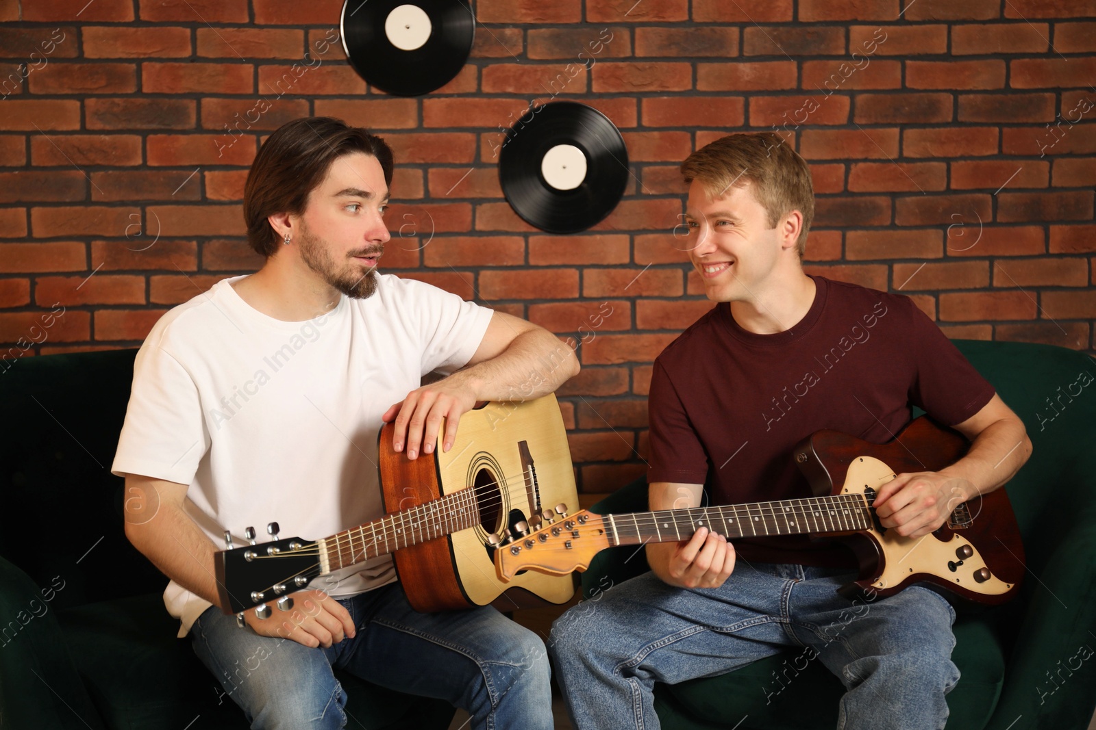 Photo of Tutor teaching man to play guitar indoors
