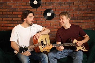 Photo of Tutor teaching man to play guitar indoors