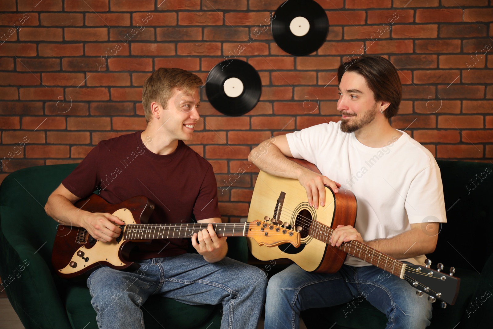 Photo of Tutor teaching man to play guitar indoors