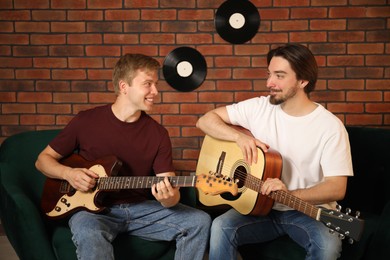 Photo of Tutor teaching man to play guitar indoors