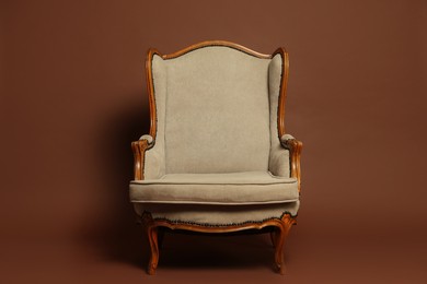 Photo of Stylish armchair on brown background. Used stuff
