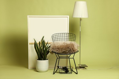 Photo of Stylish chair and other used stuff on olive background
