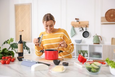Photo of Smiling woman cooking at table in kitchen