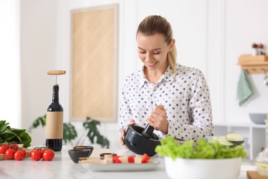Photo of Smiling woman cooking at table in kitchen