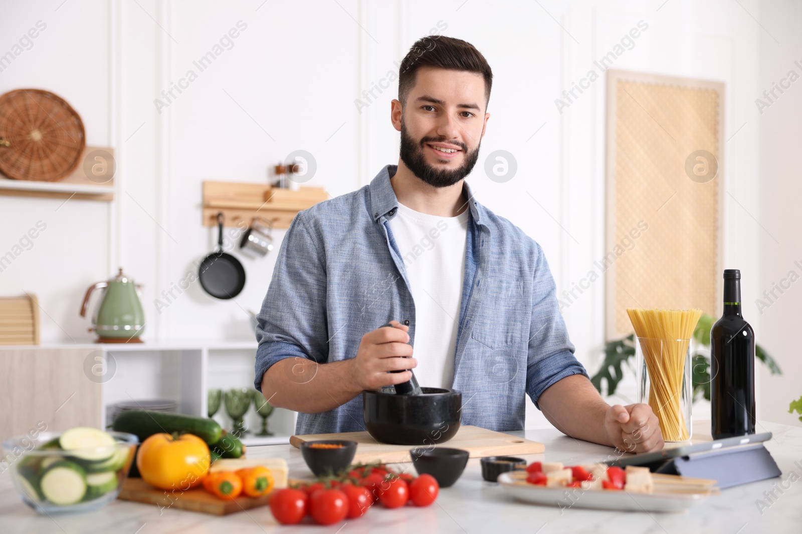 Photo of Smiling man cooking at table in kitchen