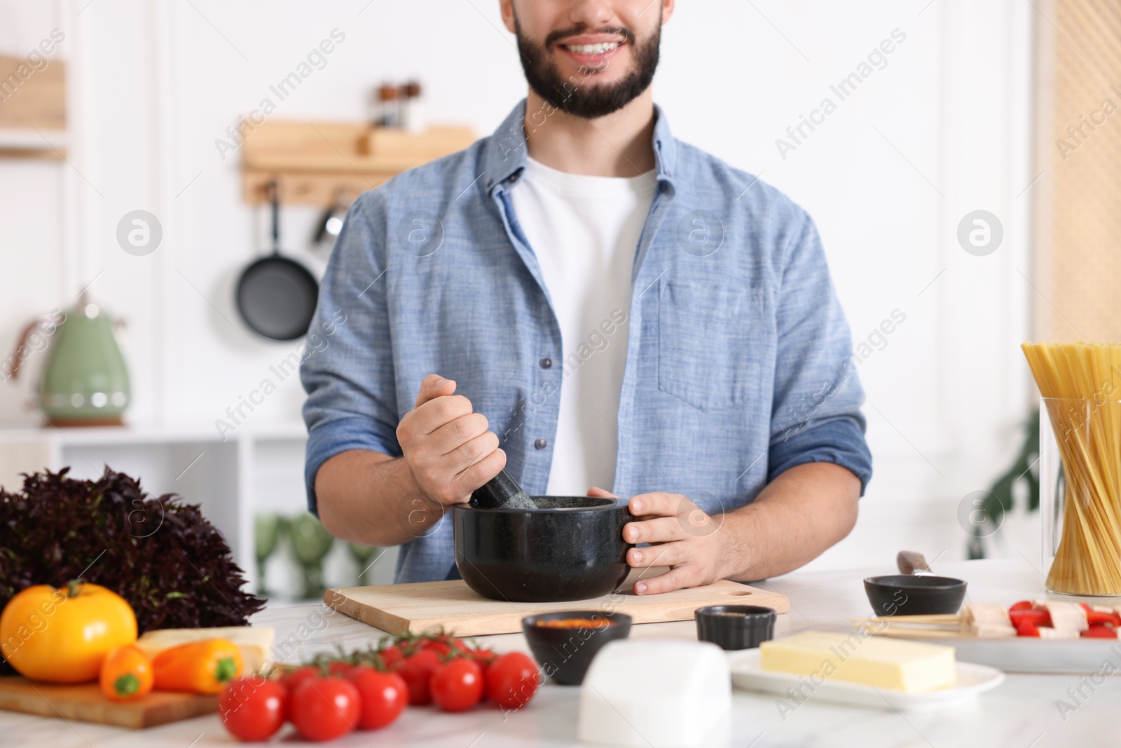 Photo of Smiling man cooking at table in kitchen, closeup