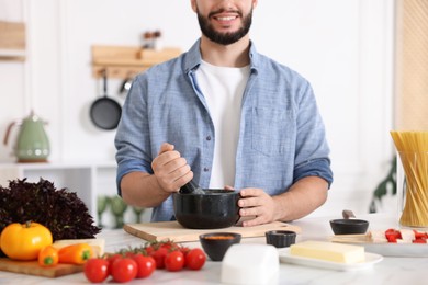 Photo of Smiling man cooking at table in kitchen, closeup
