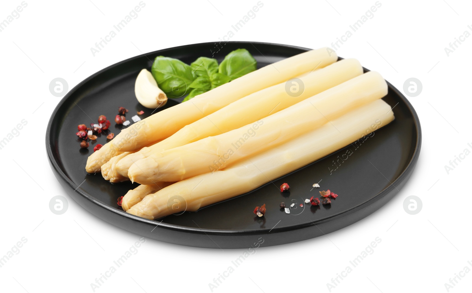 Photo of Spears of pickled asparagus with spices isolated on white