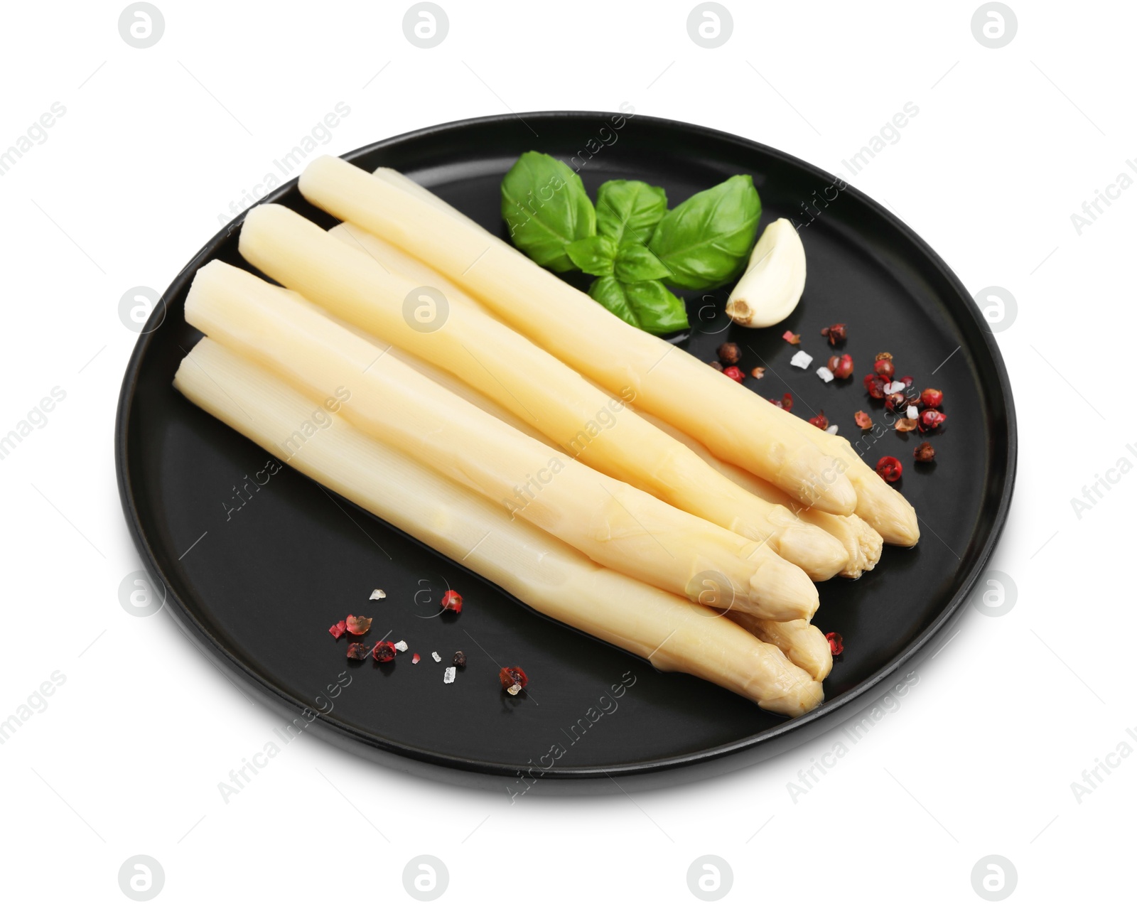 Photo of Spears of pickled asparagus with spices isolated on white