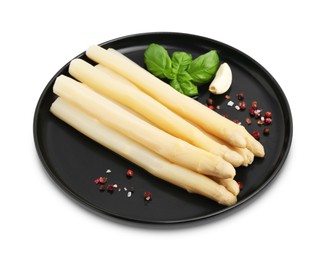 Photo of Spears of pickled asparagus with spices isolated on white