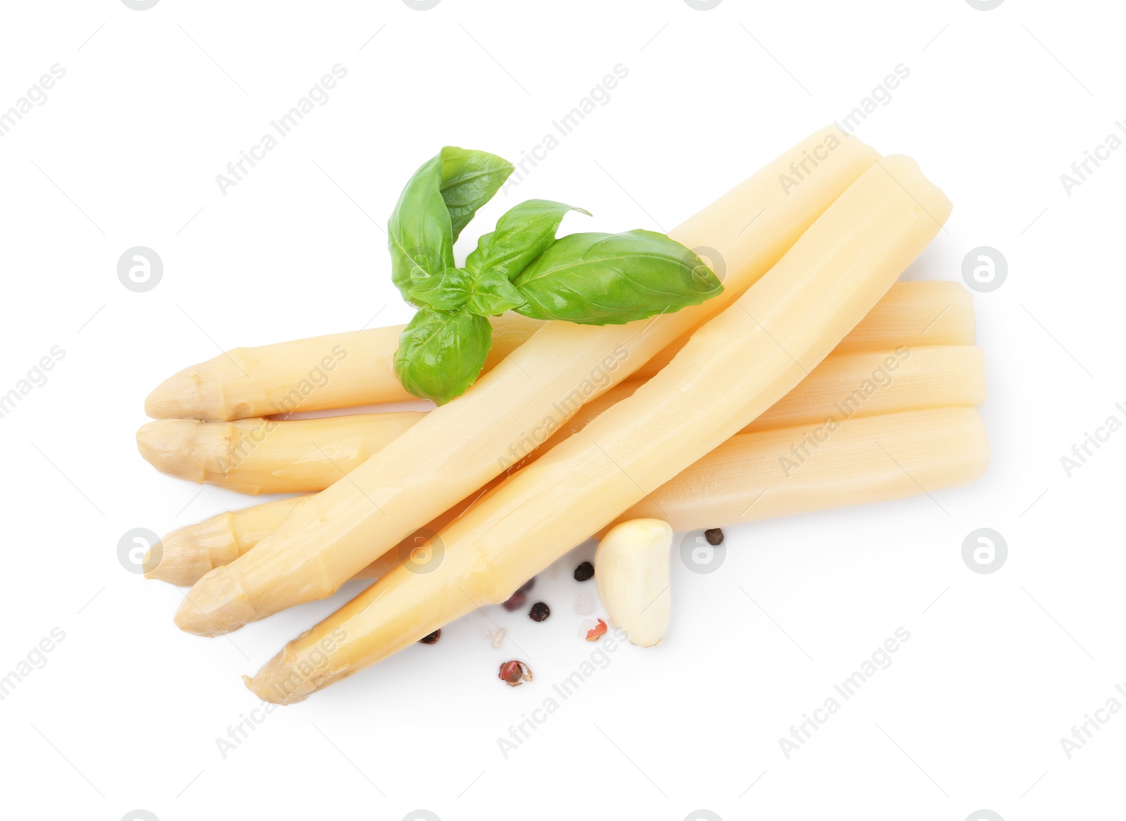 Photo of Spears of pickled asparagus with spices isolated on white, top view