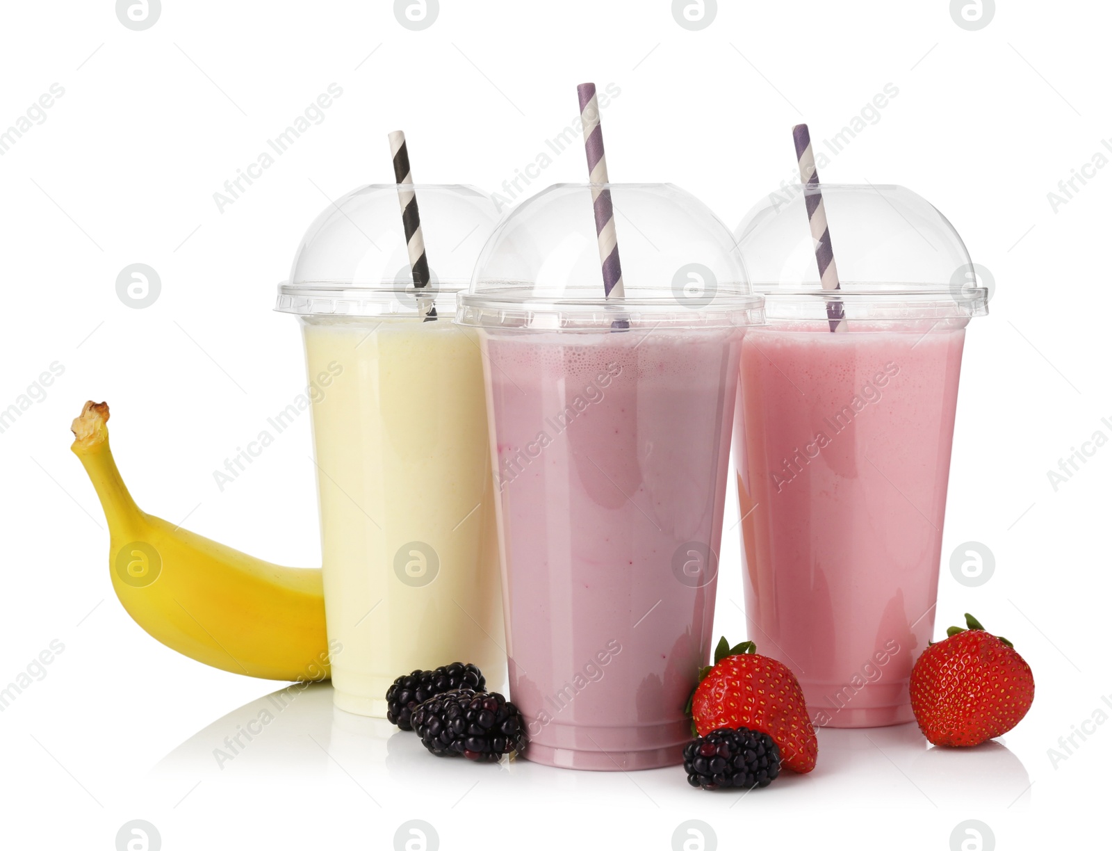Photo of Milkshakes of different flavors in plastic cups and ingredients isolated on white