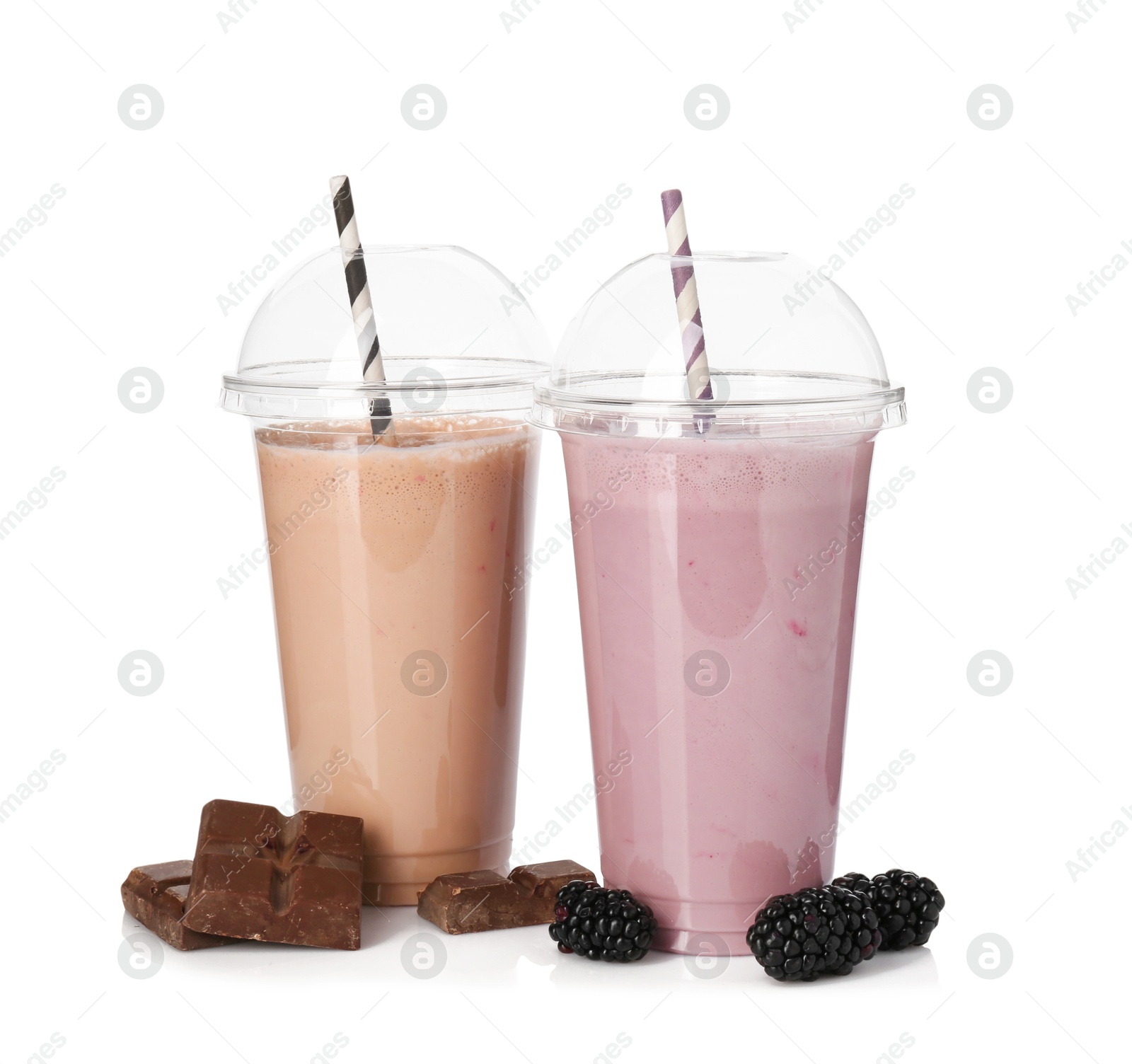Photo of Milkshakes of different flavors in plastic cups and ingredients isolated on white