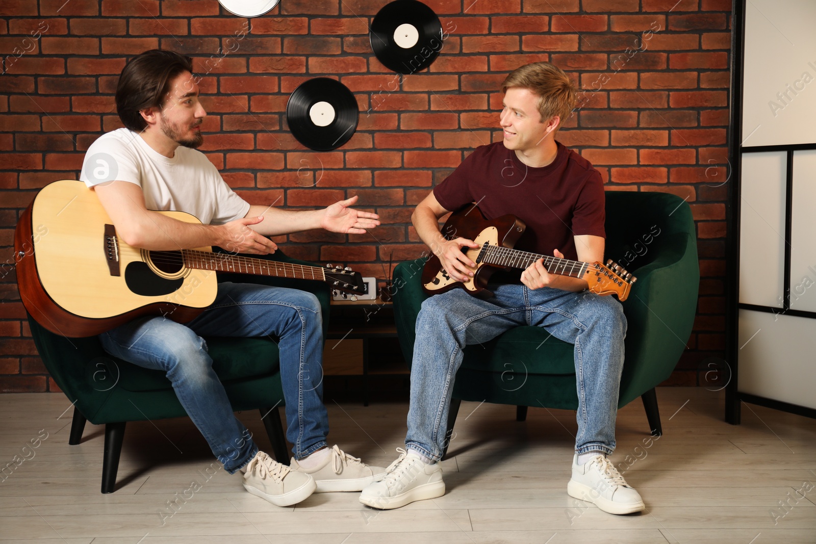 Photo of Tutor teaching man to play guitar indoors