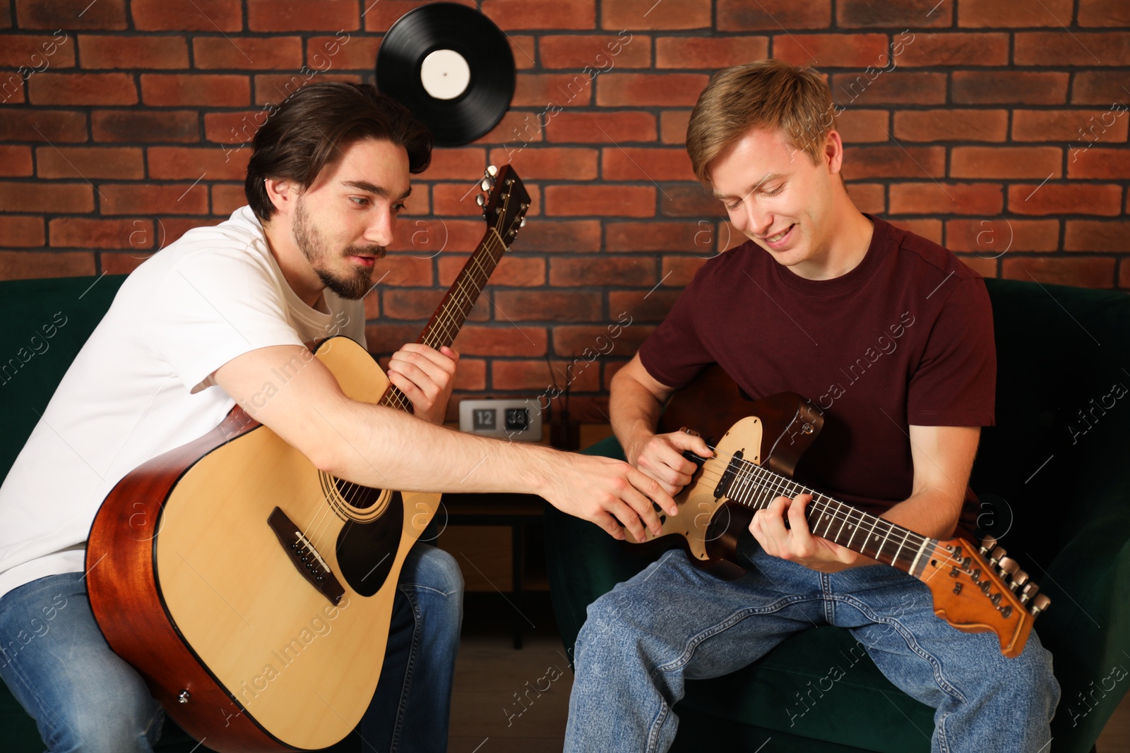 Photo of Tutor teaching man to play guitar indoors