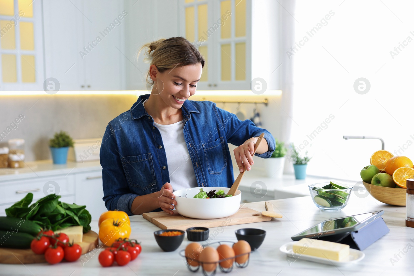 Photo of Smiling woman cooking at table in kitchen