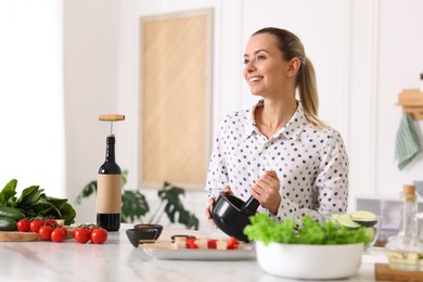 Photo of Smiling woman cooking at table in kitchen