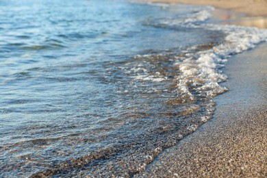 Photo of Beautiful wavy sea and sandy beach, closeup