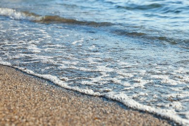 Photo of Beautiful wavy sea and sandy beach, closeup