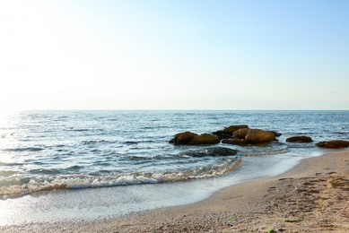 Photo of Beautiful wavy sea, stones and sandy beach