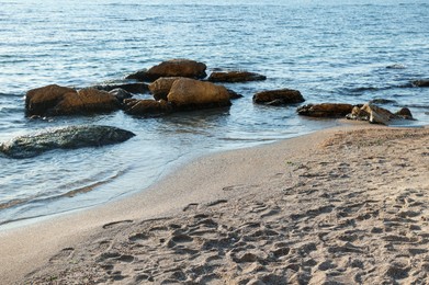 Photo of Beautiful wavy sea, stones and sandy beach