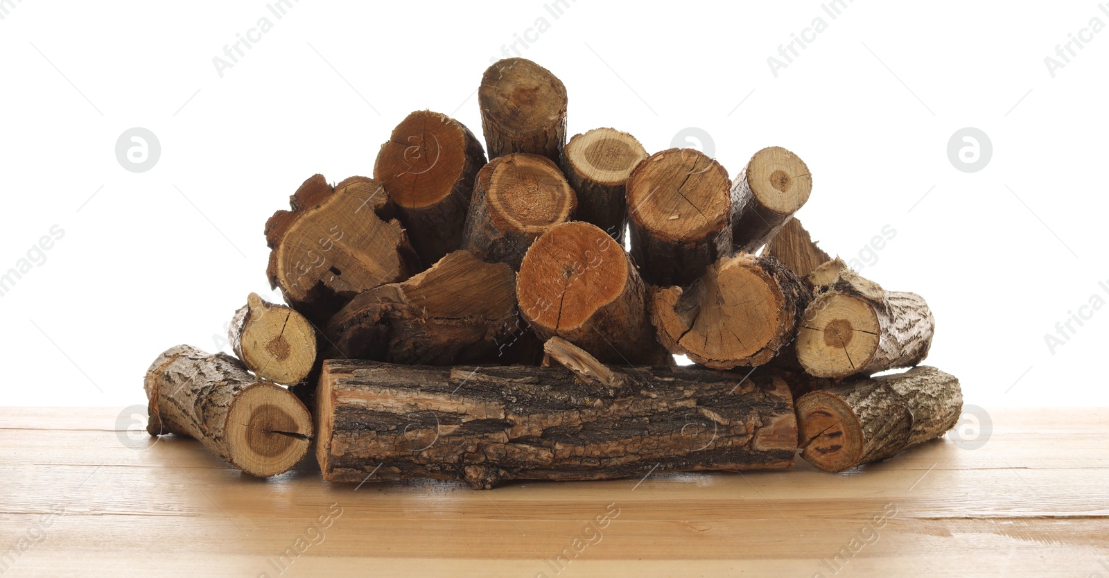 Photo of Pile of cut firewood on wooden table against white background