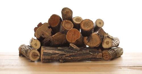Photo of Pile of cut firewood on wooden table against white background