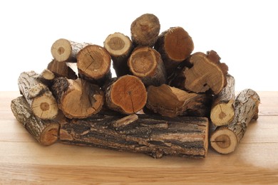 Photo of Pile of cut firewood on wooden table against white background