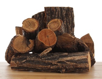 Photo of Pile of cut firewood on wooden table against white background