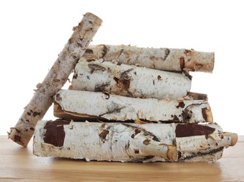 Photo of Pile of cut firewood on wooden table against white background