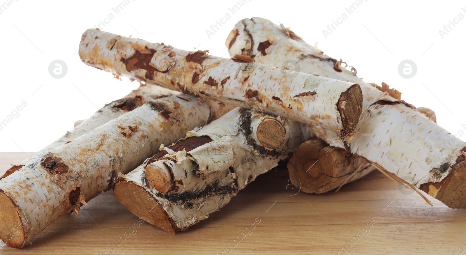 Photo of Pile of cut firewood on wooden table against white background