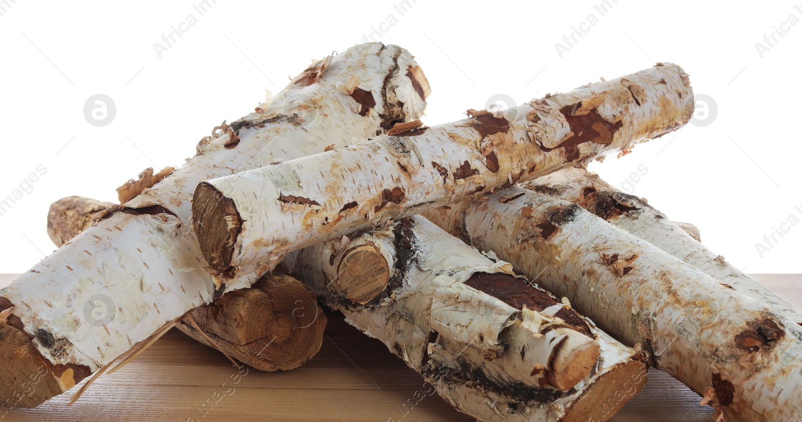 Photo of Pile of cut firewood on wooden table against white background
