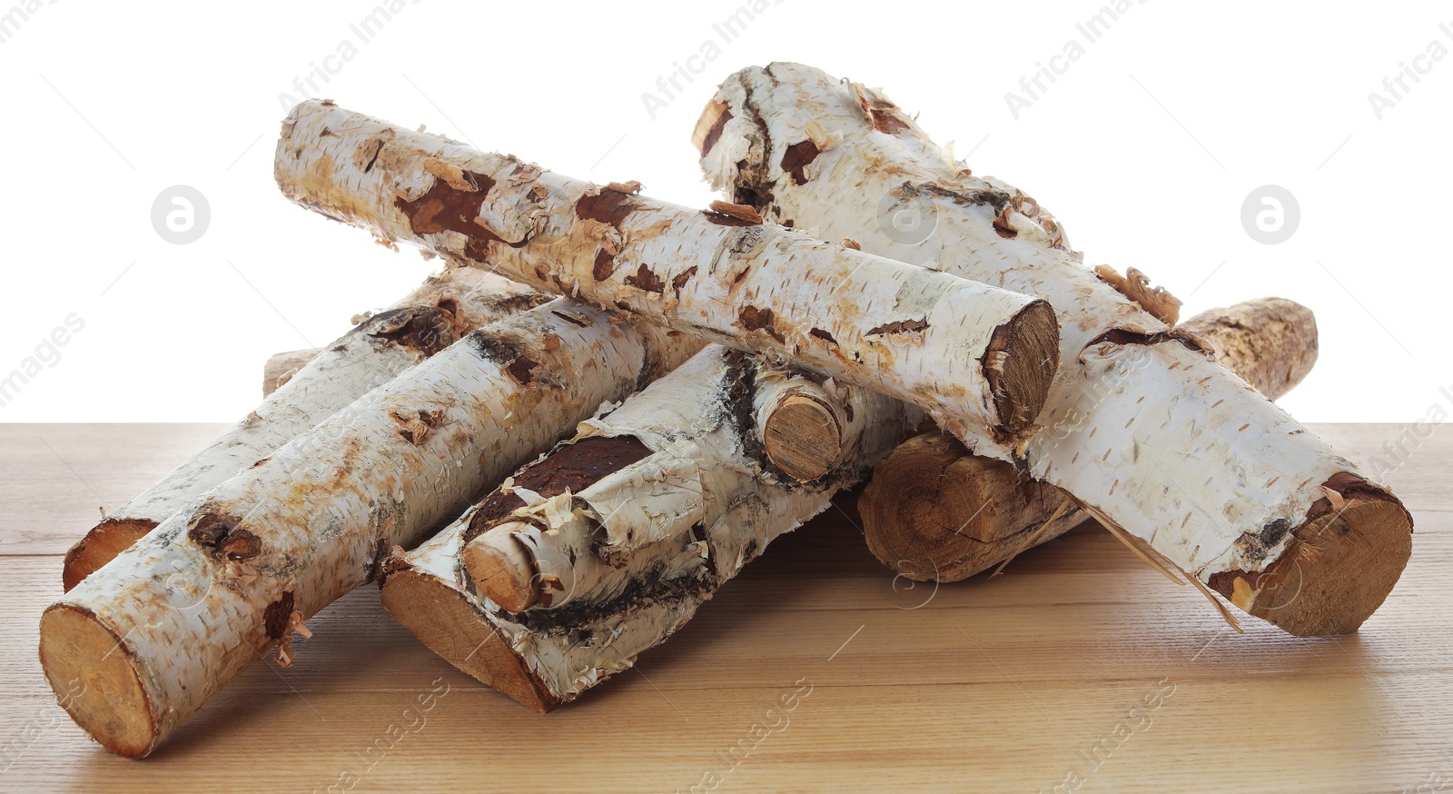 Photo of Pile of cut firewood on wooden table against white background