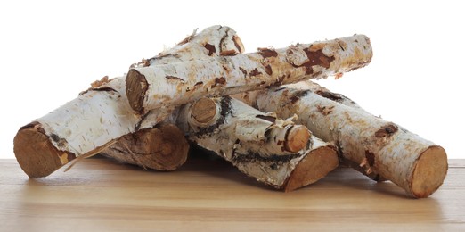 Photo of Pile of cut firewood on wooden table against white background