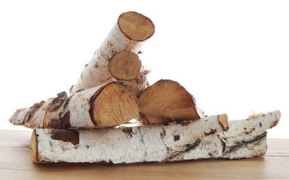 Photo of Pile of cut firewood on wooden table against white background