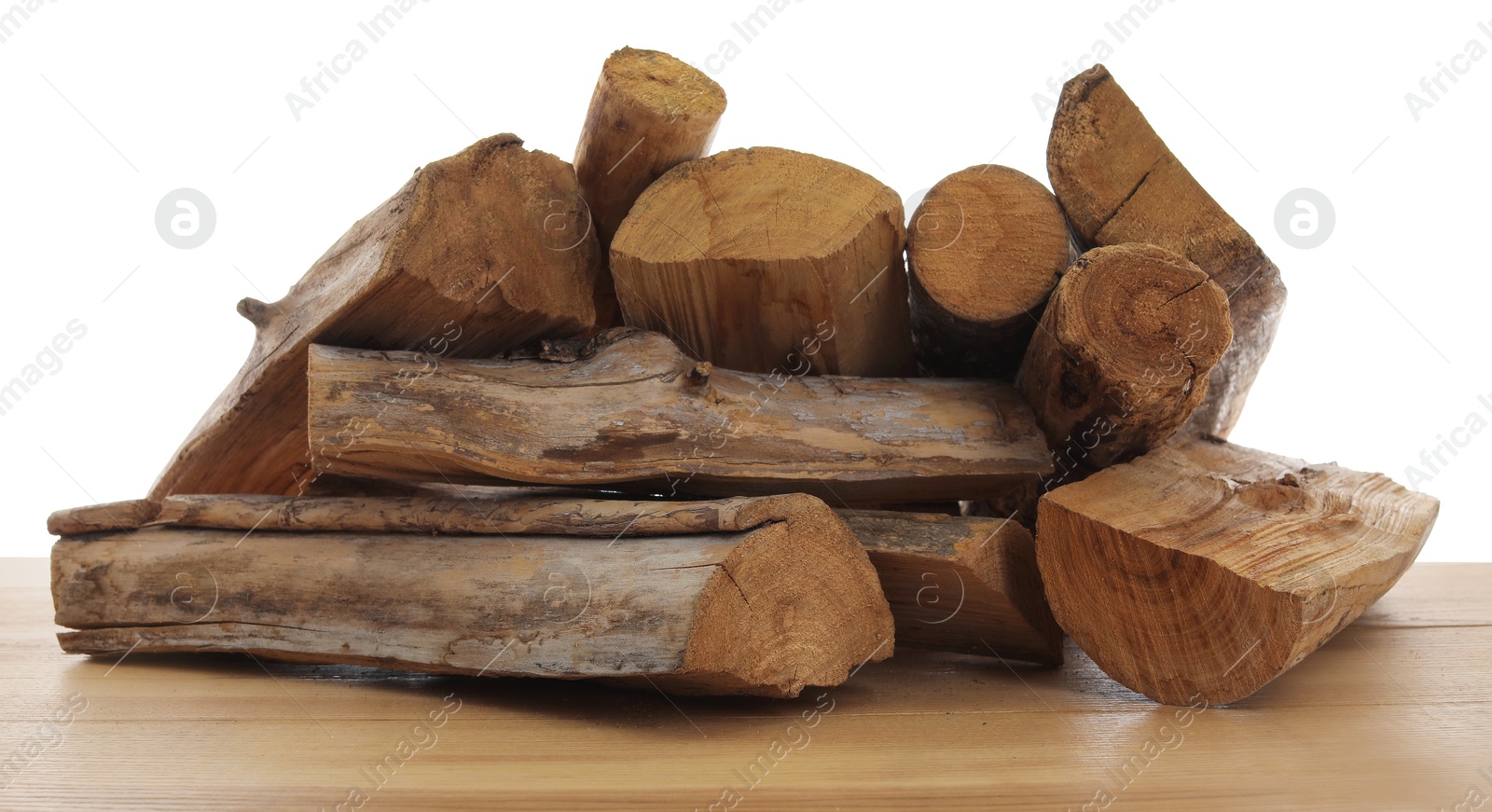 Photo of Pile of cut firewood on wooden table against white background