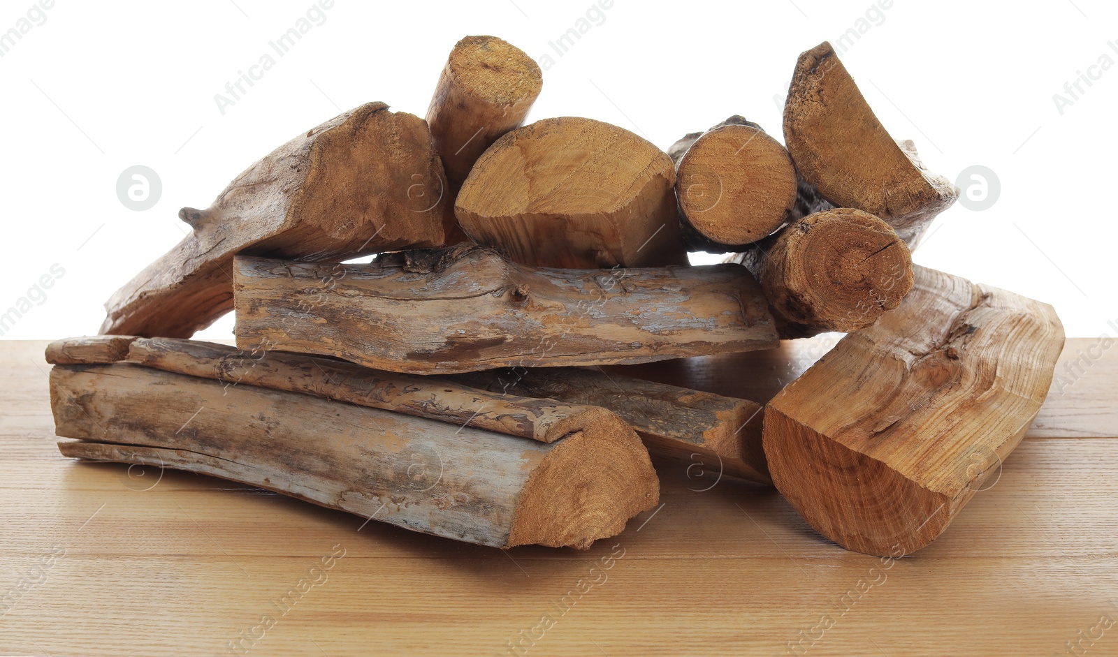 Photo of Pile of cut firewood on wooden table against white background