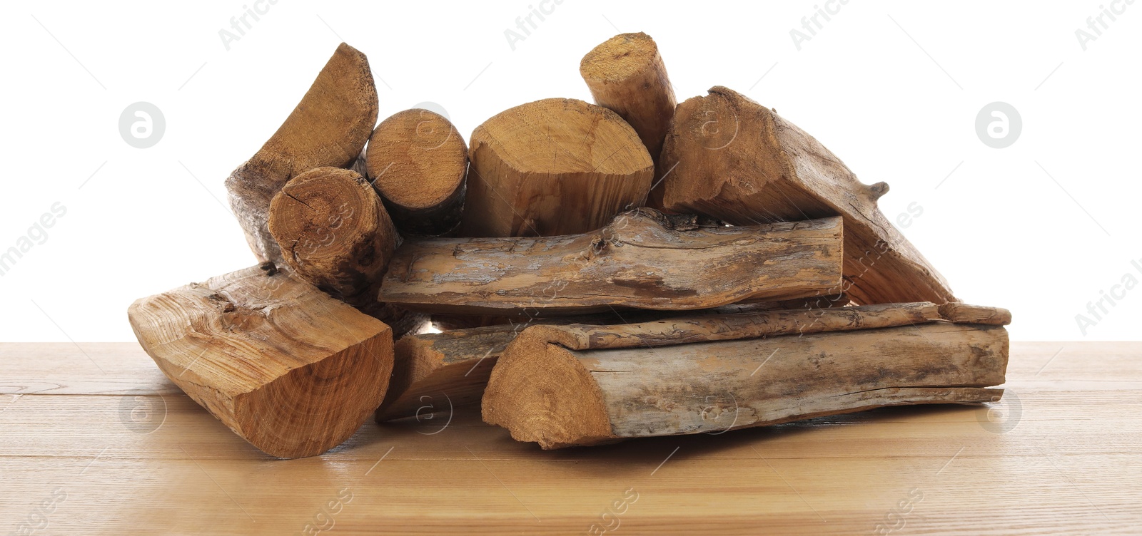 Photo of Pile of cut firewood on wooden table against white background