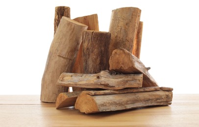 Photo of Pile of cut firewood on wooden table against white background