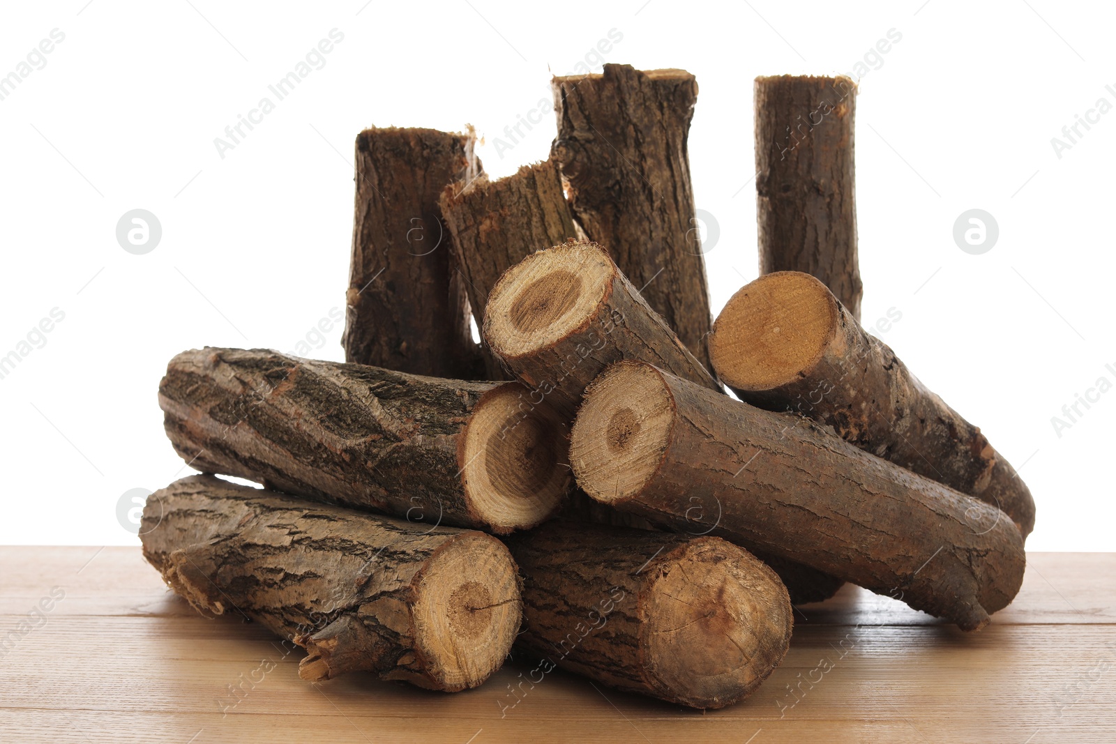 Photo of Pile of cut firewood on wooden table against white background