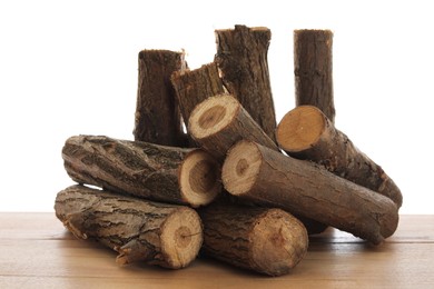 Photo of Pile of cut firewood on wooden table against white background