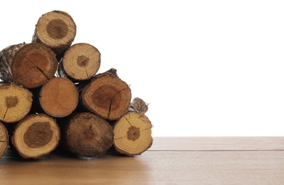 Photo of Pile of cut firewood on wooden table against white background